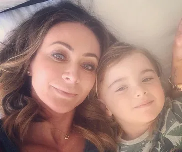 Two individuals lying together, one adult and one child, looking at the camera with relaxed expressions.