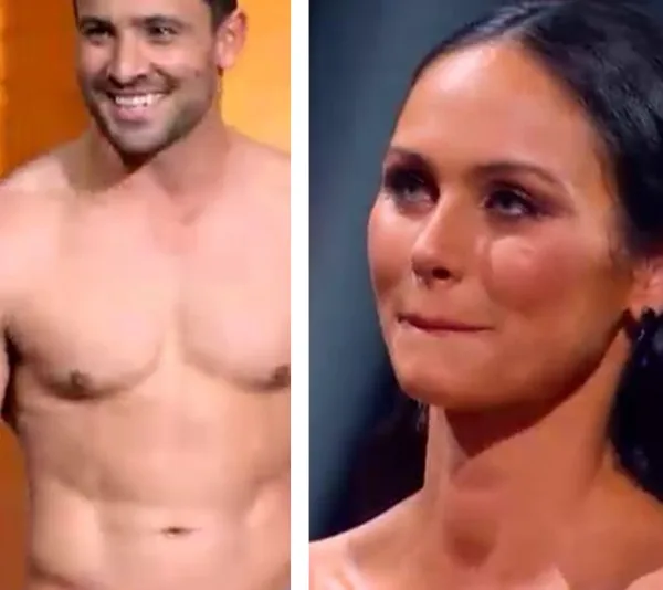 Man smiling shirtless and woman looking slightly nervous, both appear to be contestants on a TV show.