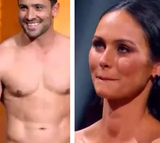 Man smiling shirtless and woman looking slightly nervous, both appear to be contestants on a TV show.