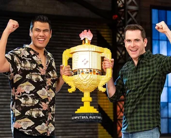 Two men celebrating with a large LEGO trophy, winners of LEGO Masters Australia 2019.