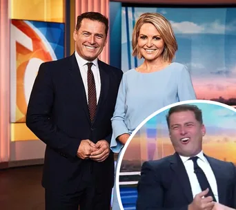 "Two TV presenters smiling in a studio, with a small inset of one laughing. Office setting with screens in the background."