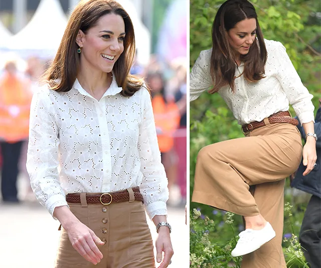 Kate Middleton in a white blouse and tan pants, wearing white sneakers, walking and stepping in a garden.