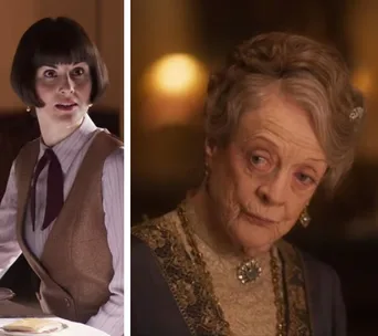 Two women in vintage attire; one seated at a table, the other wearing a brooch, from a scene in Downton Abbey movie.