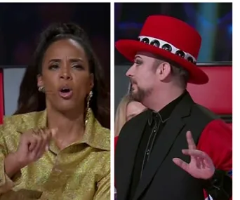 Two judges on a talent show: one in a gold outfit talking, another in a red hat listening attentively.