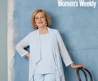 Woman in light blue suit leaning on a chair against a blue background, with "The Australian Women's Weekly" text above.