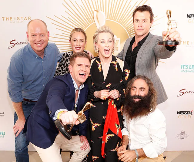 Group of six people at TV Week Logie Awards, excited and holding trophies, smiling for the camera.