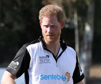 A man in a polo shirt with "Sentebale" logo, outdoors during a polo event.