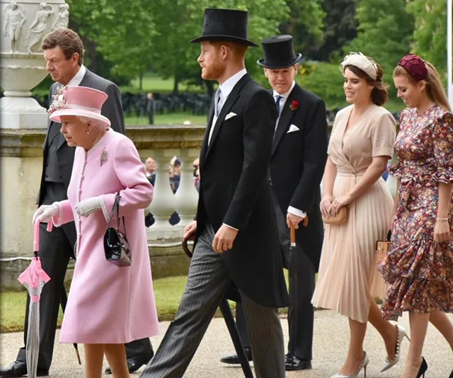 Royal family members at a garden party, Queen in pink, Prince in formal attire, and others elegantly dressed.