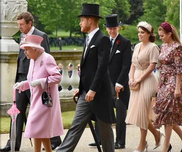 Royal family members at a garden party, Queen in pink, Prince in formal attire, and others elegantly dressed.