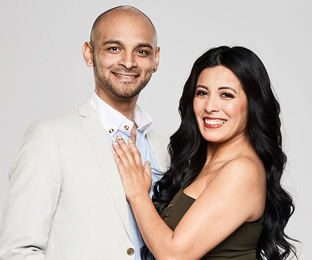 A smiling couple, Kendrick and Romina, from "The Super Switch," pose closely in a studio setting.