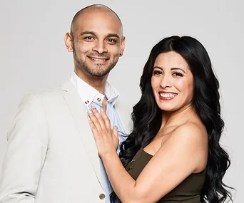 A smiling couple, Kendrick and Romina, from "The Super Switch," pose closely in a studio setting.