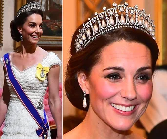 Royal woman wearing a pearl and diamond tiara, white gown, and sash, smiling during a formal event.