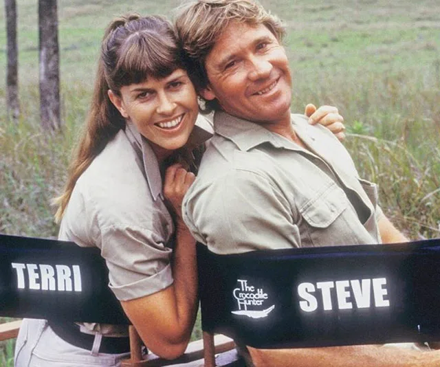 Couple in khaki attire sitting on chairs labeled "Terri" and "Steve" with "The Crocodile Hunter" logo, outdoors.