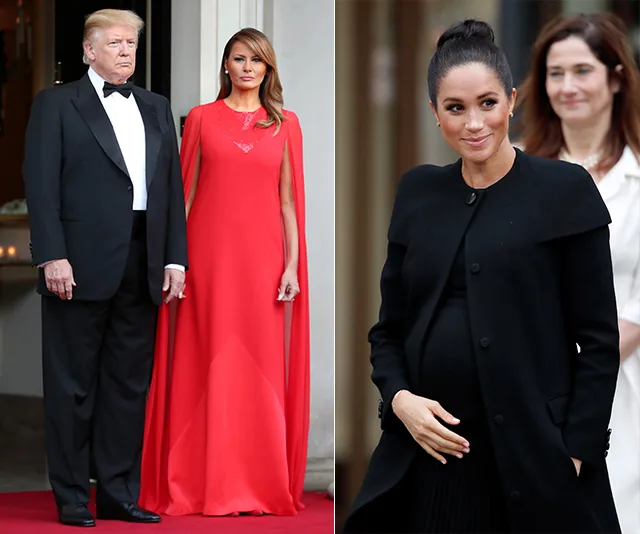 Two women in elegant dresses; one in red, the other in black, with a man in a tuxedo standing next to the woman in red.