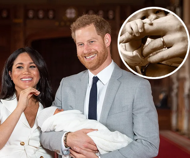 Family holding a newborn wrapped in a white blanket, smiling indoors, with inset of baby’s hand holding an adult finger.
