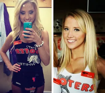 Two women in Hooters outfits, one taking a mirror selfie, both smiling with name tags saying "Olga."