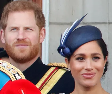 Prince Harry and Meghan Markle on a balcony during a royal event.