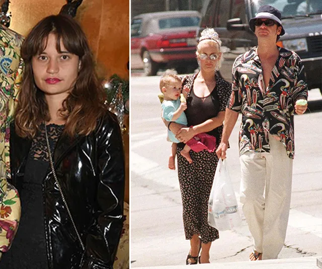 A young woman in a black jacket, and a couple walking with a baby on a city street.