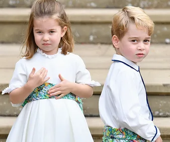 Children in formal attire on steps at a wedding.