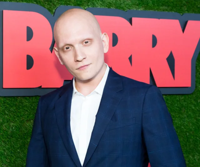 Bald man in a suit poses at an event for the TV show "Barry."