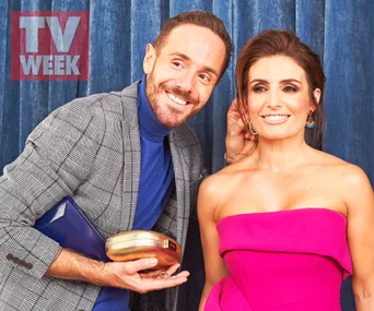 Alt text: "Smiling man and woman posing; woman in pink strapless dress, man in plaid jacket with clutch, TV Week backdrop."
