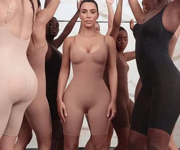 Women in shapewear bodysuits standing confidently in a diverse group.
