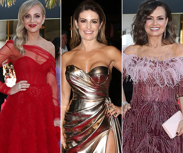 Red carpet event with three women in stylish gowns: one in red, one in metallic, and one in maroon with feather details.