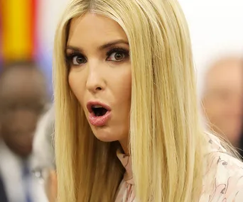 A surprised woman with long blonde hair, mouth open, in a formal setting.
