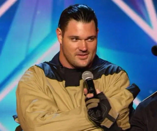 An individual on stage in a performance outfit holding a microphone during Australia's Got Talent audition.