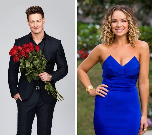 Man in a black suit holding roses and woman in a blue dress smiling outside.