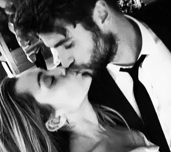 A couple sharing a kiss, captured in a black and white close-up photo.