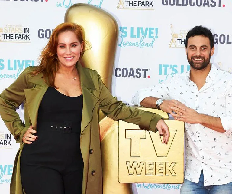 Two smiling people posing in front of a large TV Week Logie award display at a Gold Coast event backdrop.