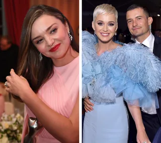 Miranda Kerr in a pink dress and Katy Perry with Orlando Bloom in blue attire at an event.