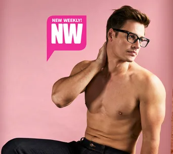 Shirtless man with glasses striking pose against pink background with NW logo.