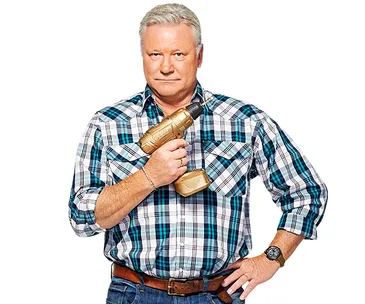 A person in a plaid shirt holds a golden drill, standing confidently with one hand on hip.