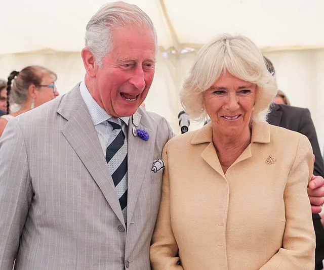 Prince Charles and Camilla smiling together at an event during their New Zealand tour.