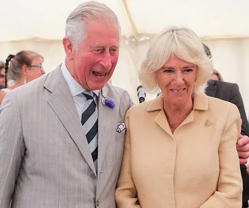 Prince Charles and Camilla smiling together at an event during their New Zealand tour.