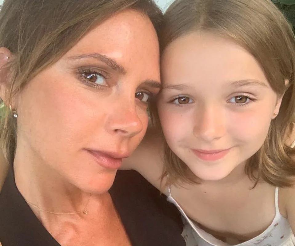 A woman and a young girl take a close-up selfie, smiling softly at the camera.