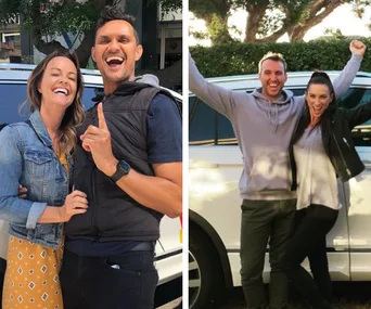 Couples celebrate in front of a car, smiling and waving joyfully.