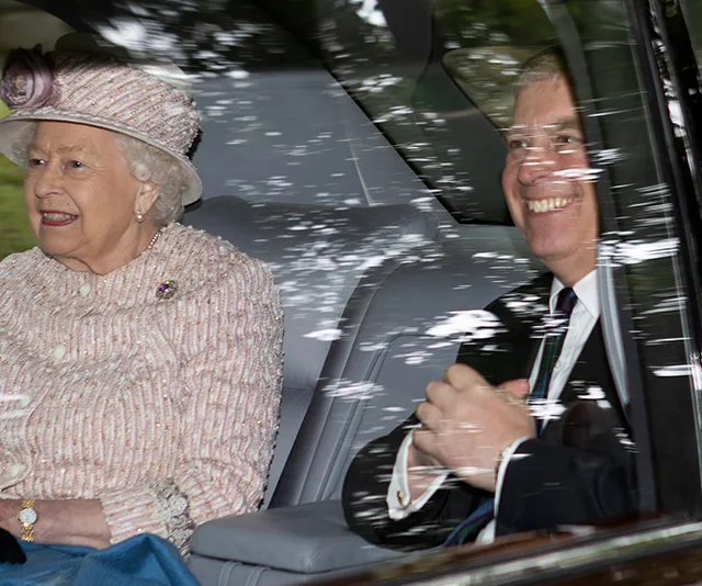 Queen and Prince Andrew in a car at Balmoral, both smiling, with trees reflected on the window.