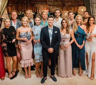 Group photo of "Bachelor in Paradise" contestants holding roses, standing together in a tropical setting.