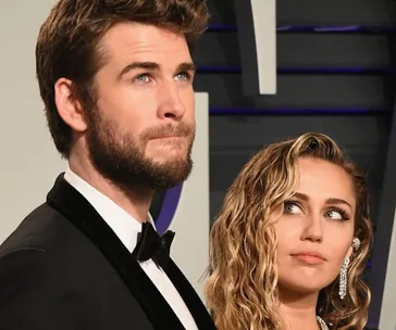 Actors at an event, one looks forward pensively, the other glances upwards with a neutral expression.