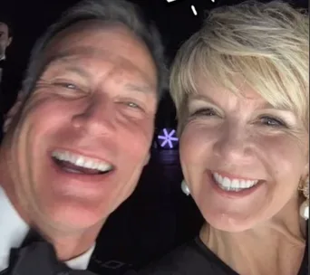 Two people smiling widely in a close-up selfie at an event.