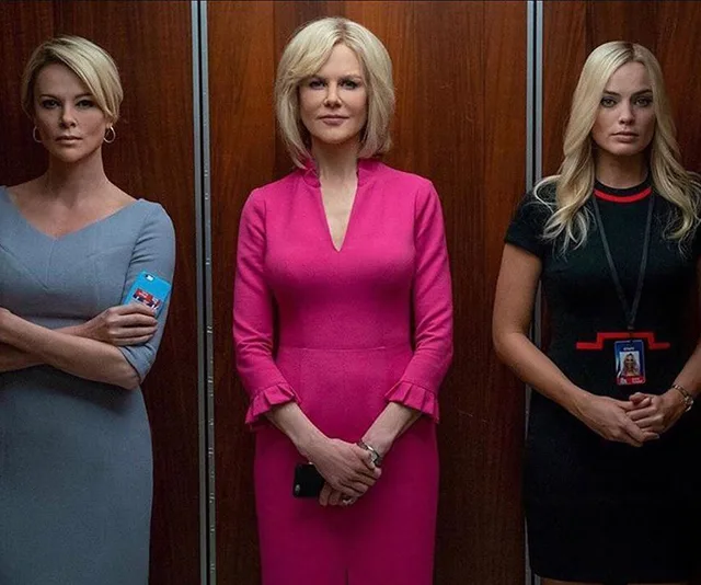 Three women, dressed formally, stand in an elevator. The scene is from the movie "Bombshell."