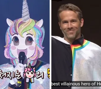 Unicorn-masked performer on stage with Ryan Reynolds smiling wearing a multicolor cape beside them.