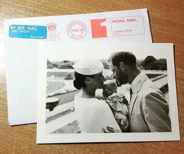 A black-and-white photo of a couple with a baby, placed on a Royal Mail envelope with postmarks.