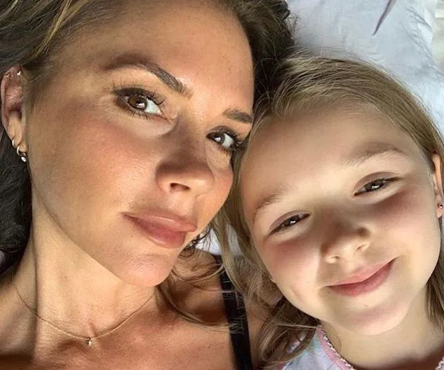 Adult and child lying down together, smiling at the camera.