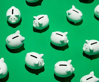White piggy banks arranged on a green background.