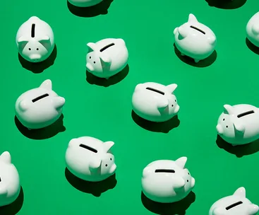 White piggy banks arranged on a green background.