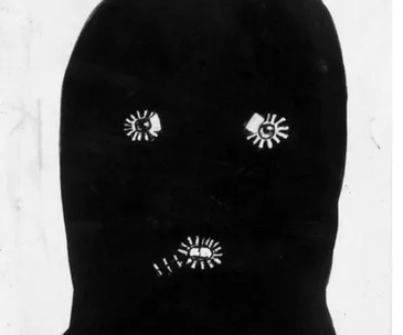 A dark mask with rough, white eye and mouth cutouts; associated with an unsolved crime case.